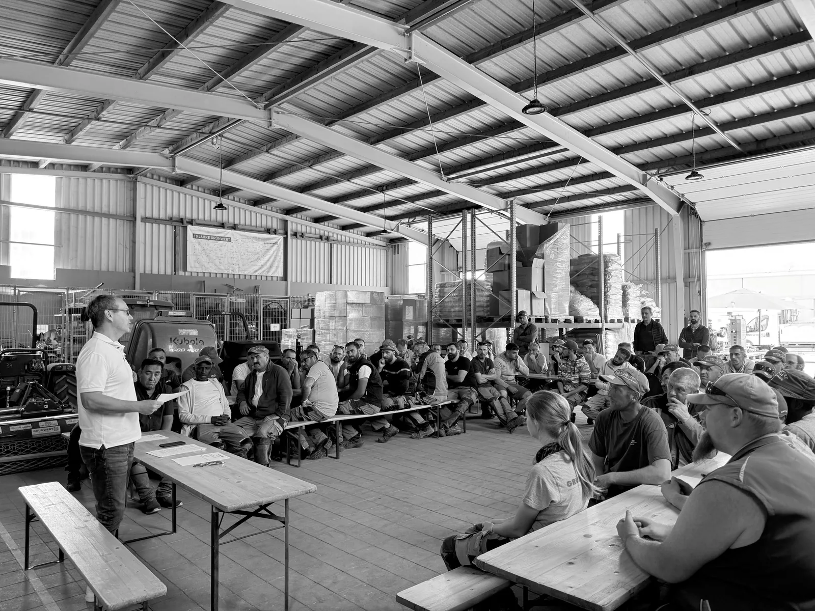 Mannschaft sitzt bei einer Schulung in der Halle am Bauhof, schwarzweiß
